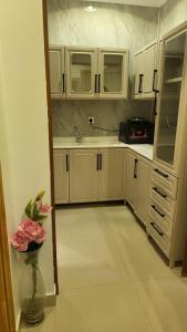 una cucina con armadi bianchi e un vaso con un fiore di شقة فاخرة VIP حي الوادي a Riyad