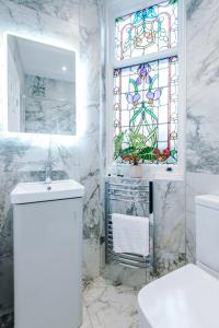 baño con lavabo y vidriera en Hilltop Serviced Apartments - Stockport, en Stockport