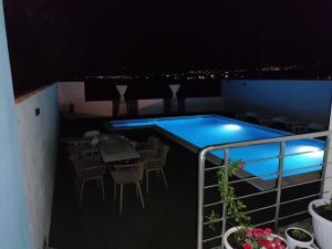a balcony with a swimming pool at night at Villa SUNFLOWER in Mostar