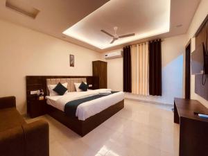 um quarto de hotel com uma cama e um sofá em The White House Haridwar em Haridwar