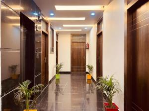 un couloir avec des plantes en pot dans un bâtiment dans l'établissement The White House Haridwar, à Haridwar