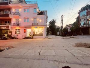 an empty street in front of a pink building at The White House Haridwar in Haridwār