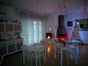 a kitchen with a christmas tree and white tables and chairs at Comeacasatua 2.0 in Bari