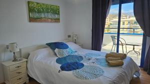 a bedroom with a bed with blue pillows and a balcony at The Beach Penthouse in Torrox Costa