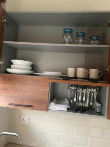 a kitchen cabinet with plates and dishes on it at Cozy Corner Homestay in Lahore