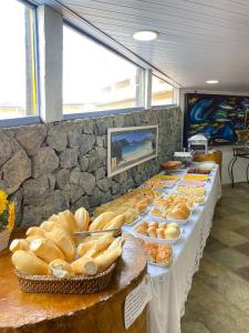 uma linha de buffet com muitos tipos diferentes de pão em Nautillus Pousada em Arraial do Cabo