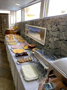 uma linha de buffet com vários produtos de pastelaria e outros alimentos em Nautillus Pousada em Arraial do Cabo