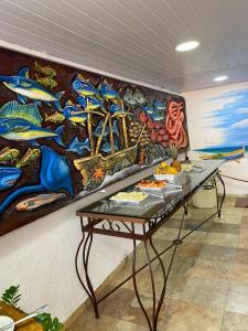 uma mesa num quarto com uma pintura na parede em Nautillus Pousada em Arraial do Cabo