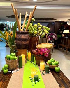 a table with candles and baskets of apples and flowers at Happy Life Green Hotel in Ho Chi Minh City