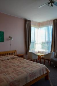 una camera con letto, tavolo e finestra di Viešbutis Ventainė a Ventė