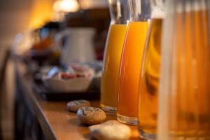 a counter with three glasses of orange juice and nuts at Hotel Val De Loire in Tours