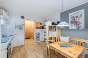 a kitchen and dining room with a wooden table at Apartment Entspannung - mitten im Ski- und Wandergebiet Spitzingsee in Schliersee