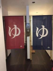 a hallway with two doors with chinese signs on them at Plum House Otaru in Otaru