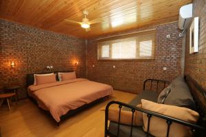 um quarto com uma cama e uma parede de tijolos em Beijing MutianyuGreat Wall Let'sgo coffee&homesty em Huairou