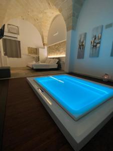 - une piscine avec des lumières bleues dans une chambre dans l'établissement Suite 87, à Mesagne