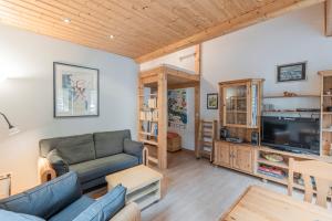a living room with a couch and a tv at Apartment Auszeit - mitten im Ski- und Wandergebiet Spitzingsee in Schliersee