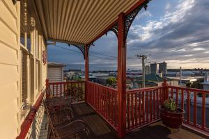 a balcony with a red railing on a house at Mersey River Cottage ( cir 1888) Central location with Amazing Ocean and Habour Views. in Devonport