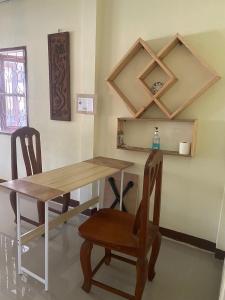 uma sala de jantar com uma mesa e duas cadeiras em Grace Little Home chiangmai em Chiang Mai