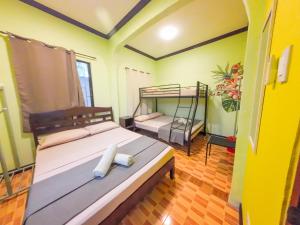 a bedroom with two bunk beds in a room at Sunrise Guesthouse and Inn, Panglao in Panglao Island