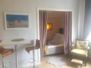 Dormitorio pequeño con cama, mesa y silla en Central hel lägenhet. Nära till allt. en Umeå
