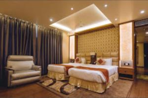 a hotel room with a large bed and a chair at The Grand Empire Best 4 Star Luxury Hotel in Patna in Patna