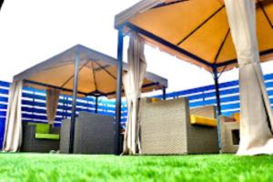 due ombrelloni con sedie e tavoli nell'erba di The Grand Empire Best 4 Star Luxury Hotel in Patna a Patna