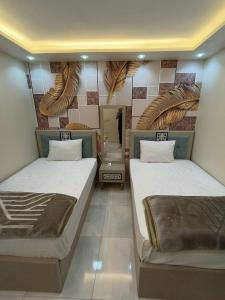 a room with two beds and a mirror at wow super lux apartment near to Nile شقة سوبر لوكس جديدة جامعة الدول العربية المهندسين in Cairo