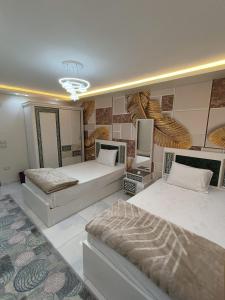 a bedroom with two beds and a television in it at wow super lux apartment near to Nile شقة سوبر لوكس جديدة جامعة الدول العربية المهندسين in Cairo