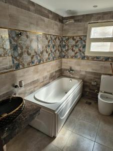 a bathroom with a white tub and a toilet at wow super lux apartment near to Nile شقة سوبر لوكس جديدة جامعة الدول العربية المهندسين in Cairo