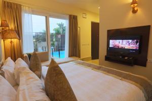 um quarto com uma cama grande e uma televisão em Sinon Baga Retreat em Baga