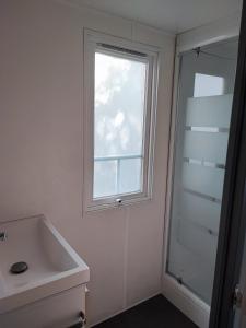 a bathroom with a sink and a window at Sun Sea camping le Bosc in Saint-Cyprien