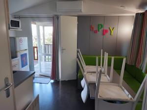 a small room with a table and a green couch at Sun Sea camping le Bosc in Saint-Cyprien