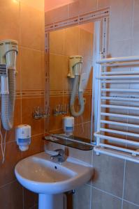 ein Bad mit einem Waschbecken und einem Spiegel in der Unterkunft Viešbutis Ventainė in Ventė