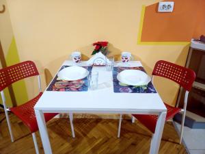uma mesa branca com duas cadeiras vermelhas e um prato branco em "Maria Luisa" - Top center apartment em Sófia