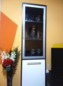 a white cabinet with glasses and a vase with flowers at "Maria Luisa" - Top center apartment in Sofia