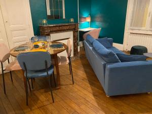 a living room with a blue couch and a table at Appartement 3 pièces avec garage in Moulins