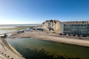 维姆勒Bellevue - Appartement 60 m2 - 3 ch - vue mer - rénové à Wimereux Plage !的建筑物旁边一大片水