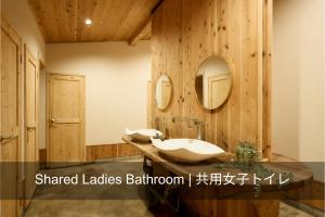 uma casa de banho com 2 lavatórios e um espelho em 自然人村 em Akiruno