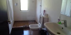 a bathroom with a white toilet and a sink at Ol Pejeta Holiday Villas in Nanyuki