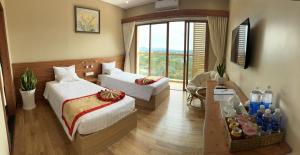 Habitación de hotel con 2 camas y ventana en Memories Hotel, en Bao Loc