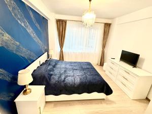 a bedroom with a bed and a tv in it at Sunset view in Craiova