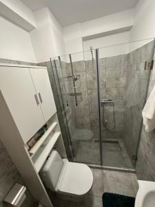 a bathroom with a toilet and a glass shower at Sunset view in Craiova +4 photos