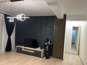 a living room with a tv and a table and a chandelier at Sunset view in Craiova