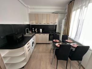 a kitchen with a table and a dining room at Sunset view in Craiova