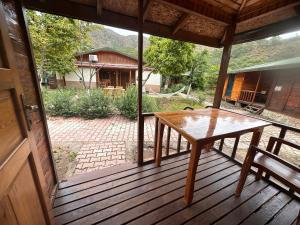a wooden porch with a table and a bench on it at Likya Yanartaş Bungalow in Kemer +23 photos