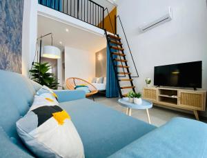 a living room with a blue couch and a tv at Modern Designed Loft in Russafa (SOHO) in Valencia