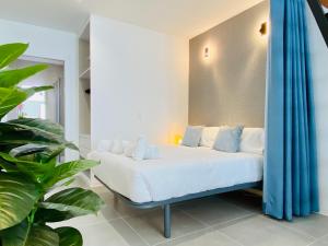 1 dormitorio con cama blanca y cortinas azules en Modern Designed Loft in Russafa (SOHO), en Valencia