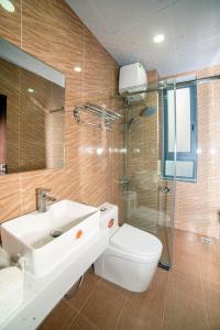 y baño con aseo, lavabo y ducha. en KP Villa Dalat en Dalat