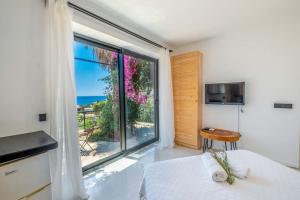 ein Schlafzimmer mit großem Fenster mit Blick auf das Meer in der Unterkunft Villa Jasmine Peninsula in Kaş