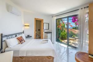 ein Schlafzimmer mit einem Bett und einem großen Fenster in der Unterkunft Villa Jasmine Peninsula in Kaş + 41 Fotos
